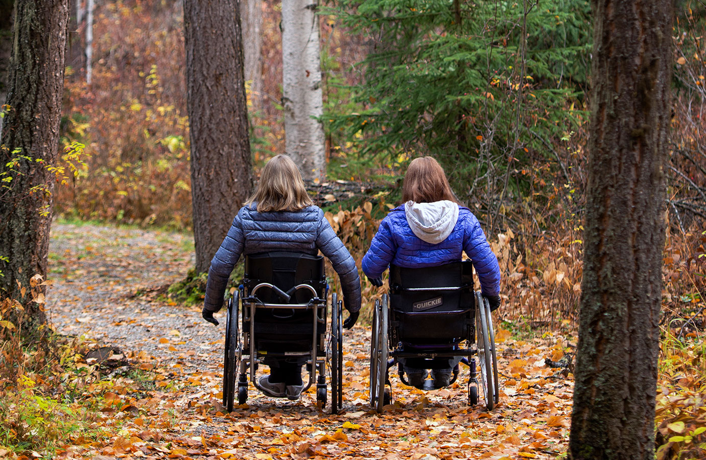 Two people on accessible trail, with wheelchairs