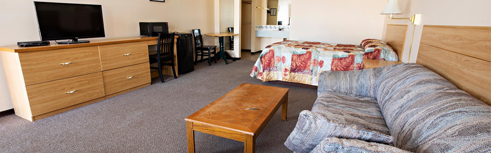 Spacious and clean bedroom with cable desk, seating, and dining area 