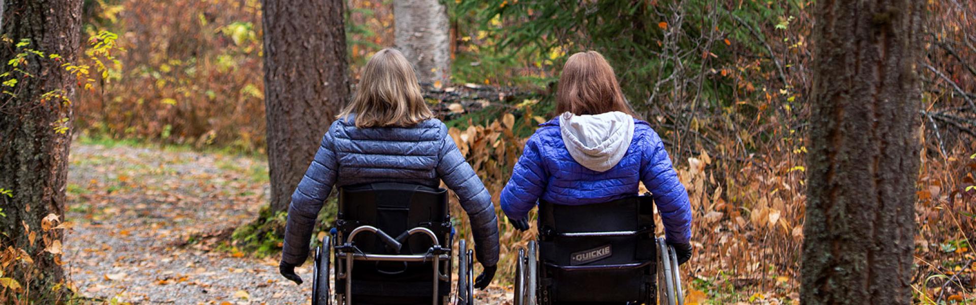 Two people on accessible trail, with wheelchairs