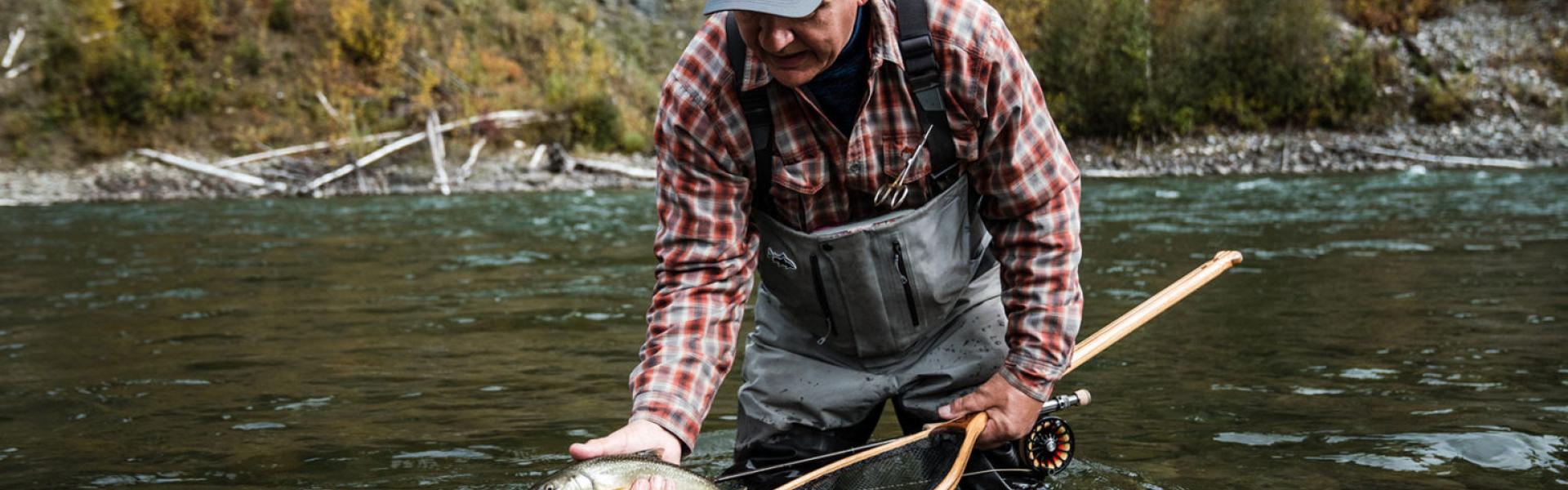 Man catching fish in river with net