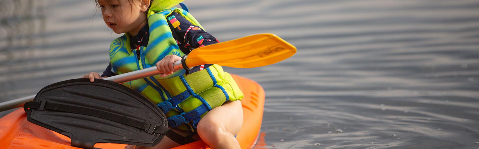 little girl in kayak on lake