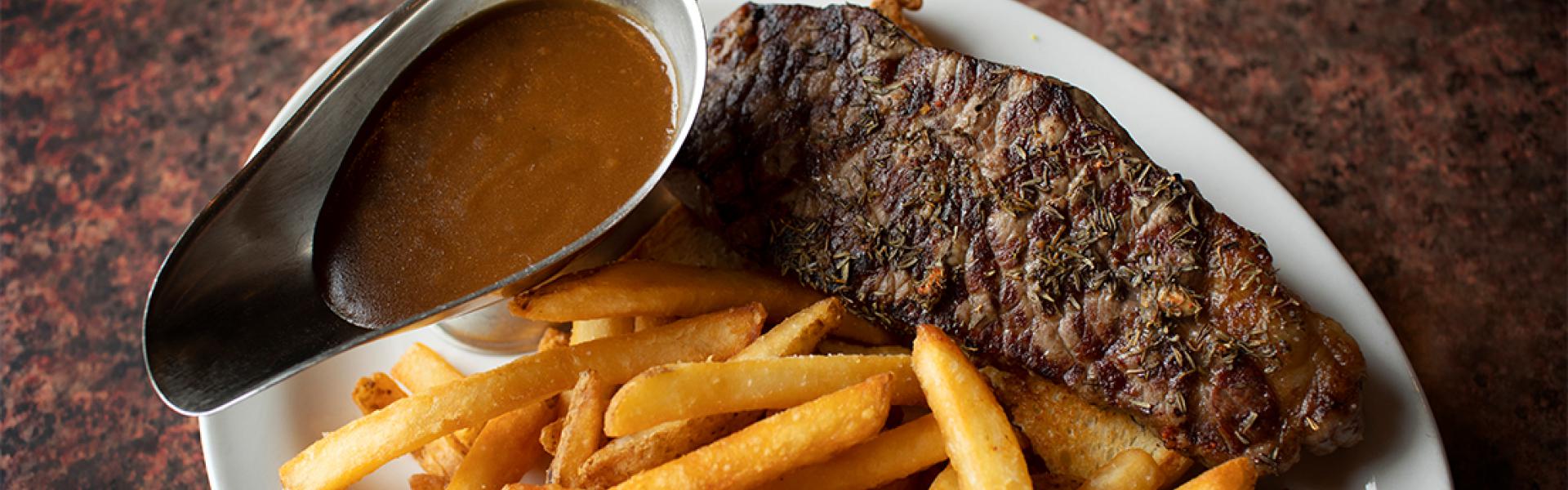 Plate of steak, fries and Barbeque sauce 