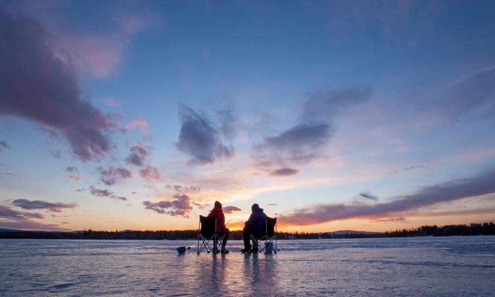 2 people ice fishing on a frozen Dragon Lake