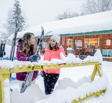 Two friends with cross-country skis outside at Hallis Lake