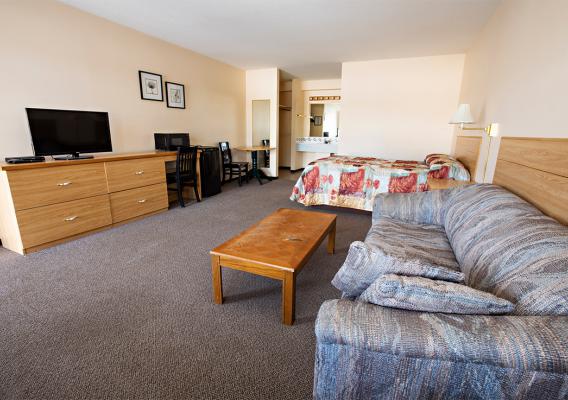 Spacious and clean bedroom with cable desk, seating, and dining area 