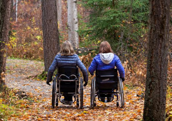 Two people on accessible trail, with wheelchairs