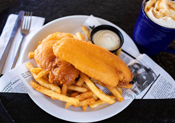 A plate of fish and chips served with tartar sauce.