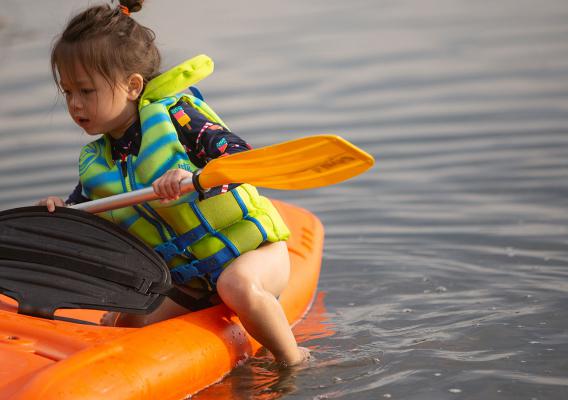 little girl in kayak on lake